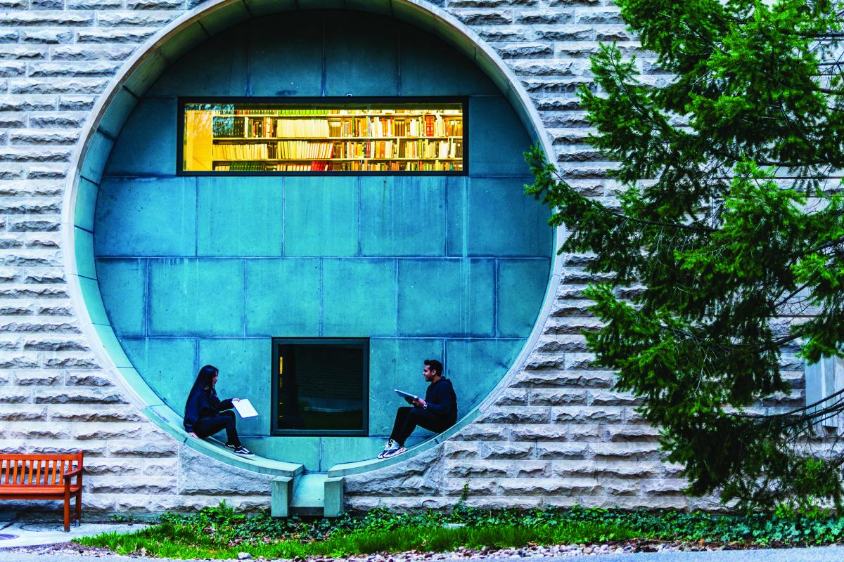 two students sitting in a circular window opening