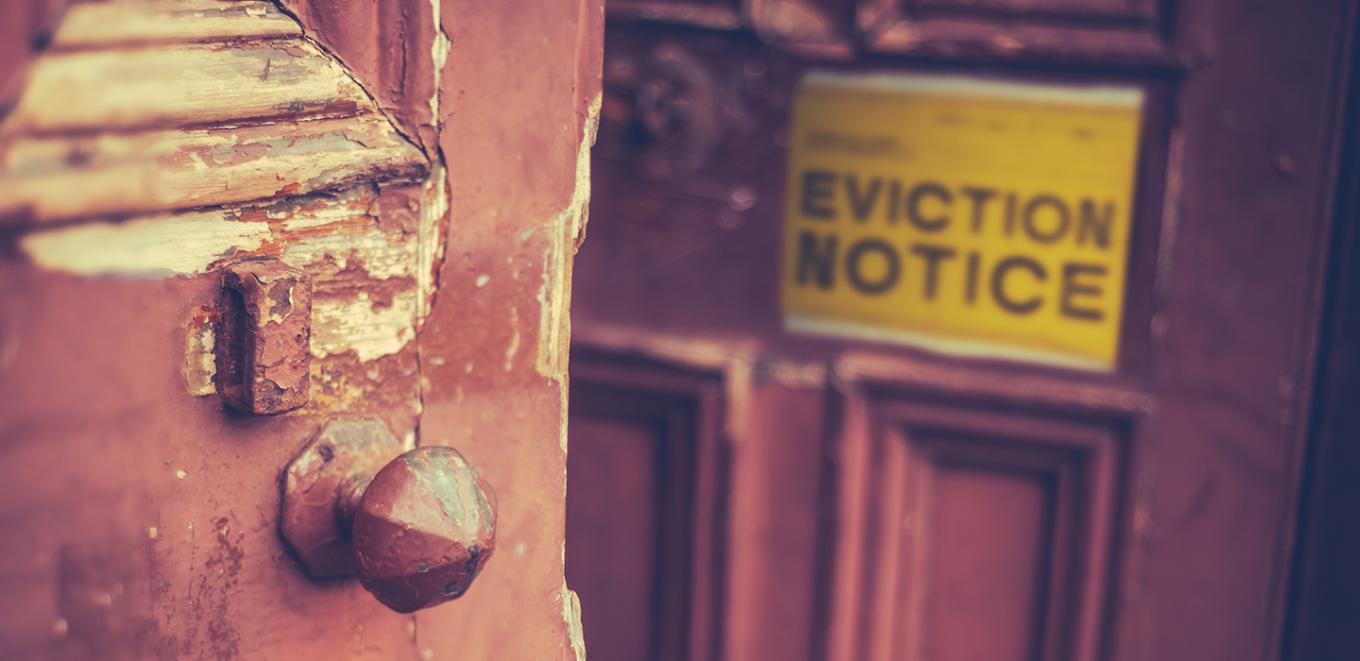 View of a door with an eviction notice attached to the front.