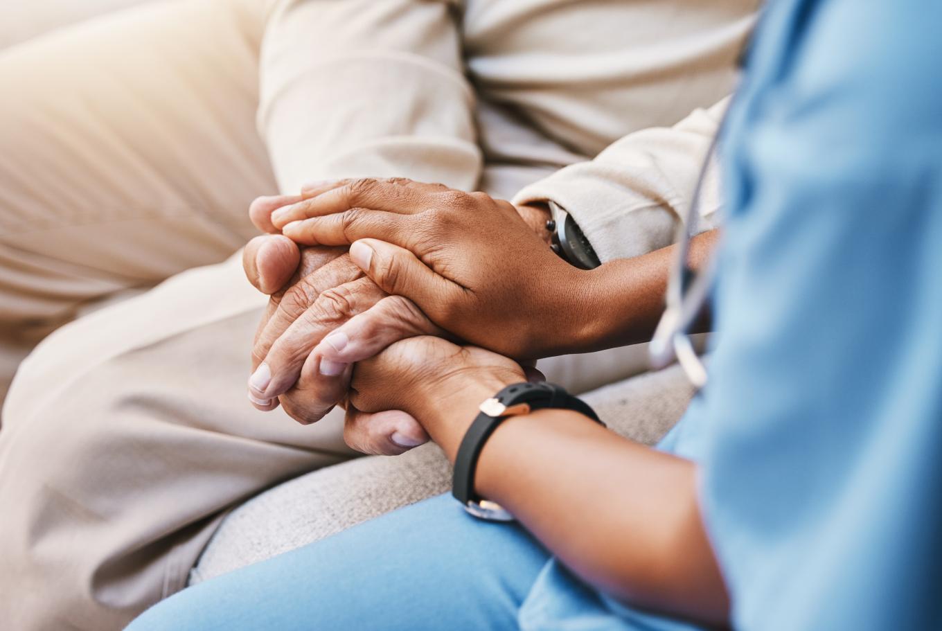 Nurse holding patient's hands