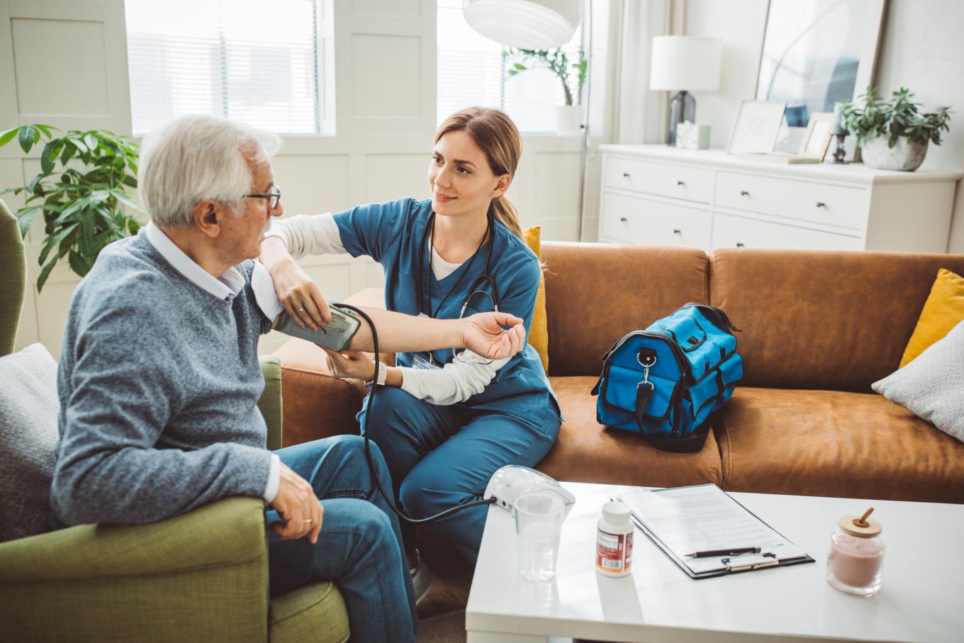 A home healthcare worker takes a man's blood pressure. 