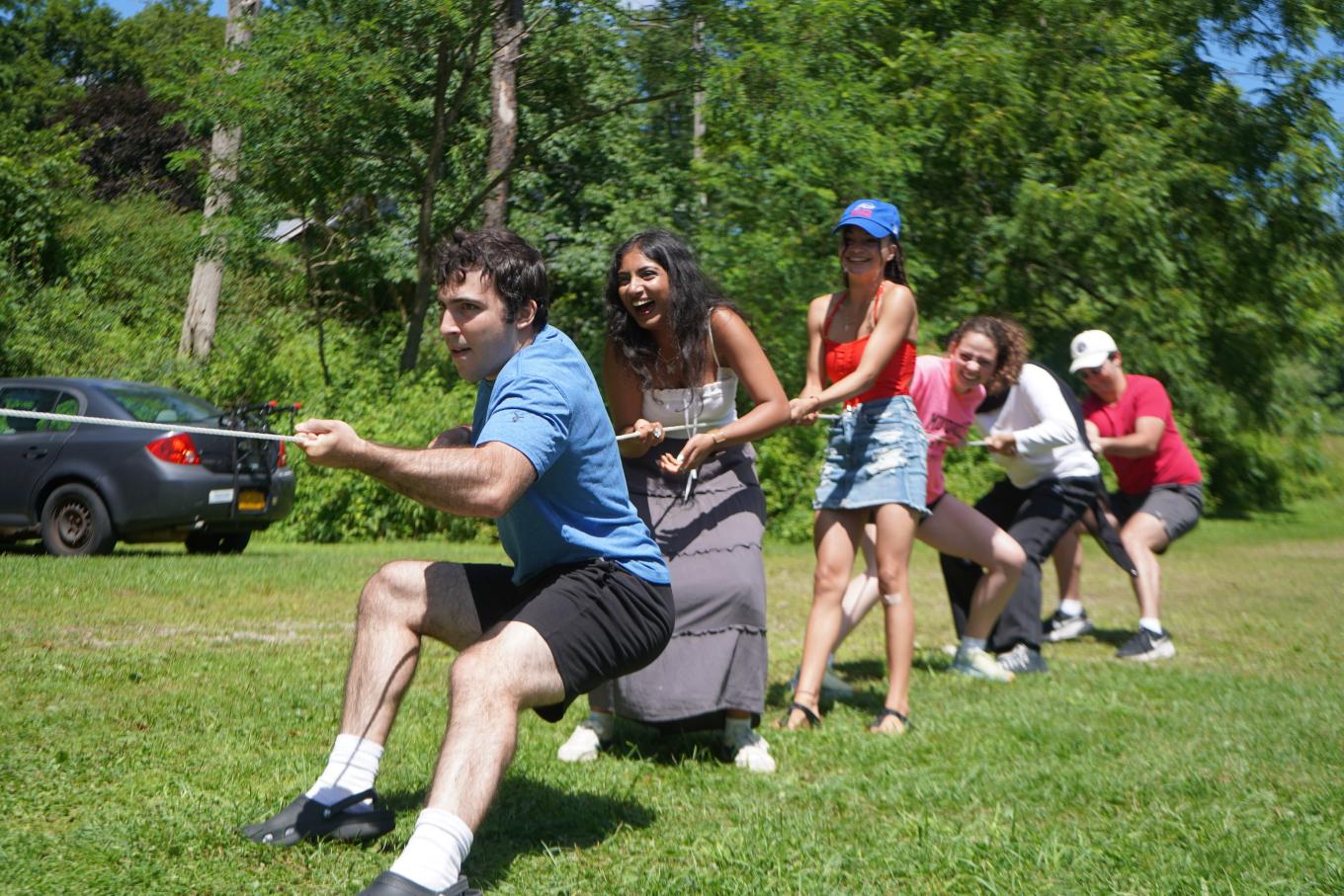 Group of students playing 'tug of war' in a park