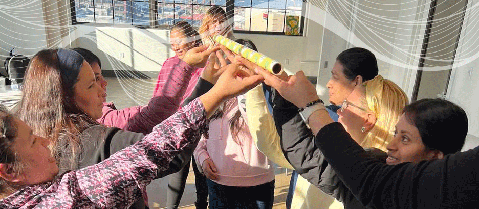 group of women using their hands as teamwork to lift an object