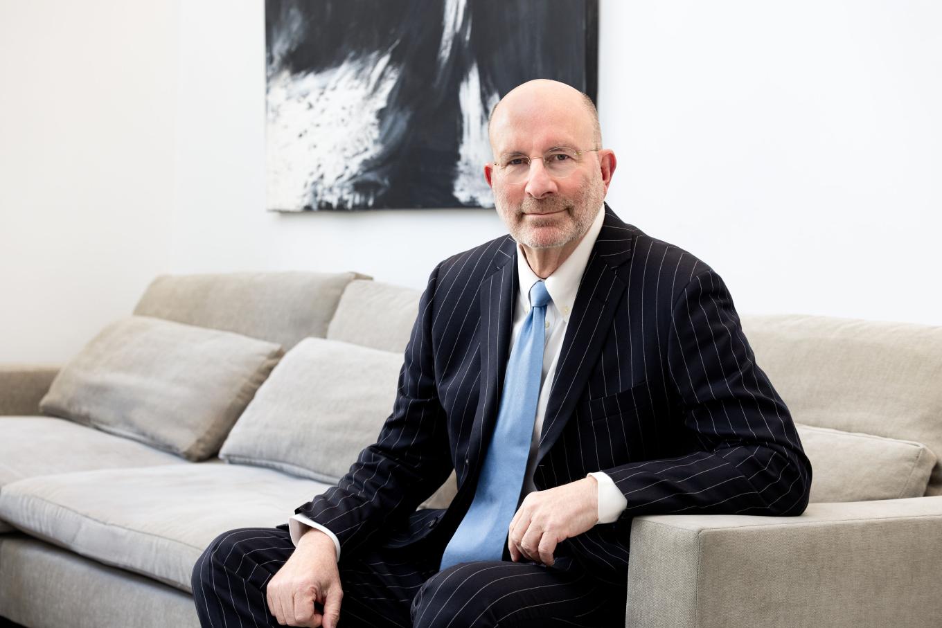 Ken Kirschner ’75 sitting on a couch in an office. 