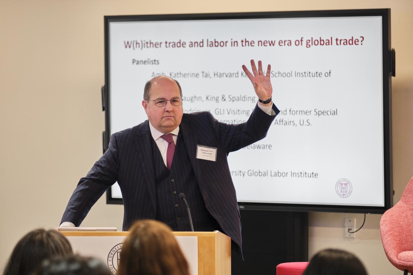 Stephen Vaughn stands at a podium at the 2025 Global Labor Institute conference in New York City, with a screen behind him listing the title of his panel discussion