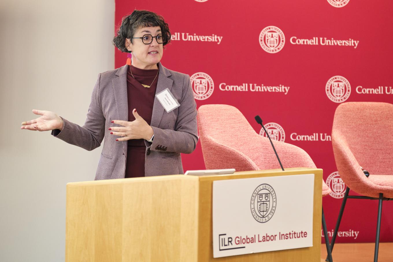 Laura Murphy stands at a podium at the 2025 Global Labor Institute conference in New York City, standing at a podium with the Global Labor Institute logo in front of it