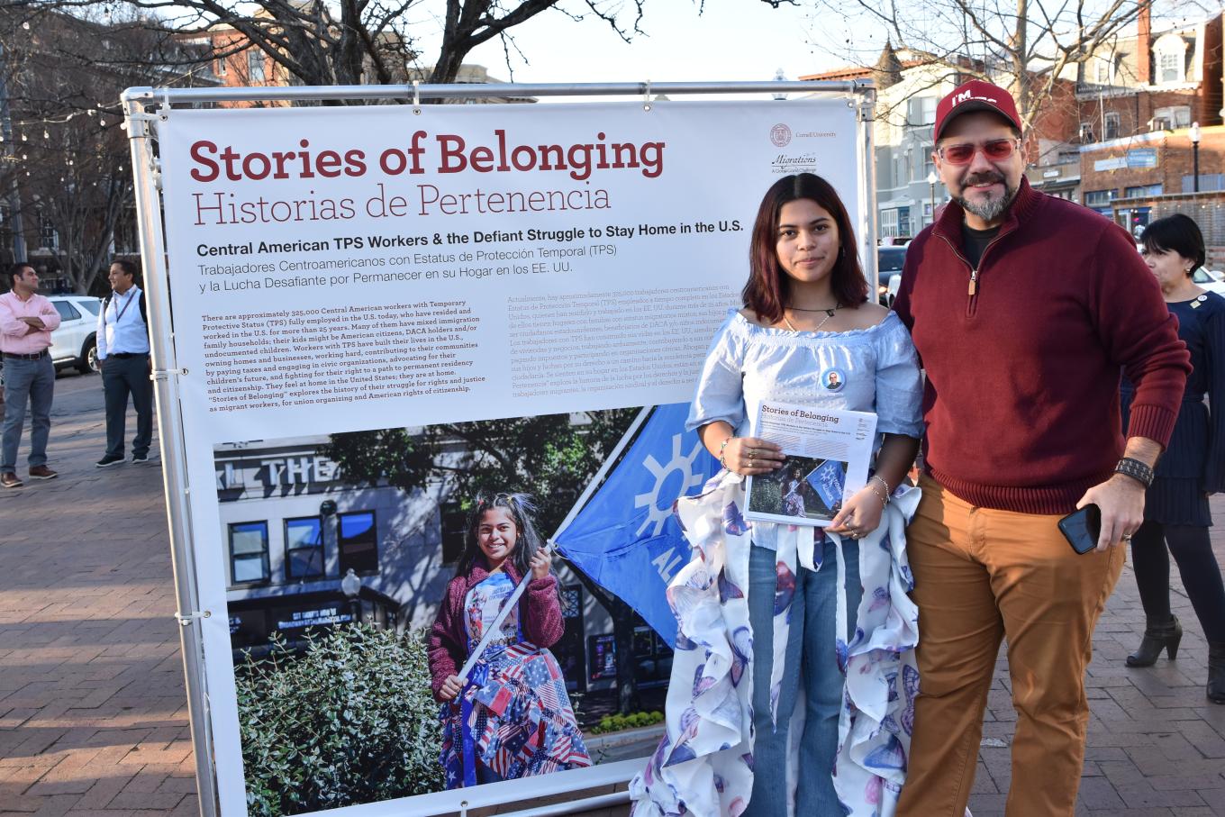 Father and daughter standing in front of exhibit images