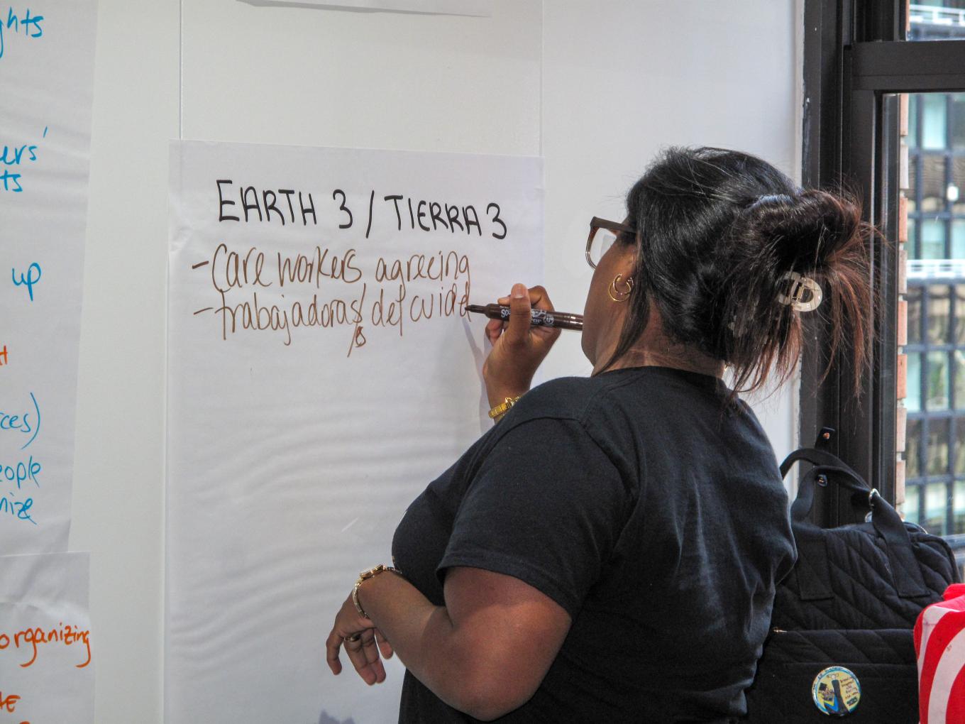 Woman writing on paper taped to the wall