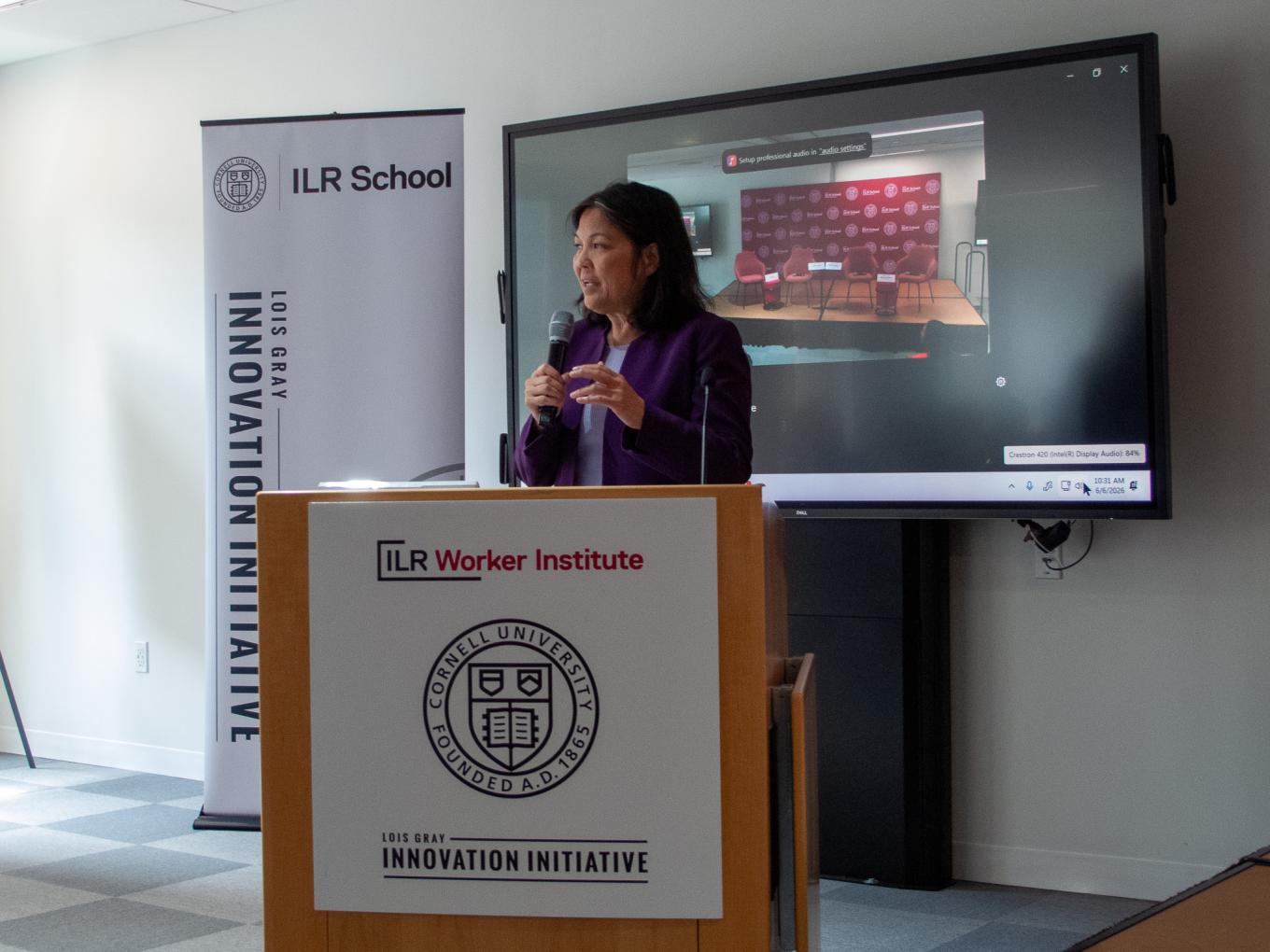 Image of Julie Su speaking on microphone at the group 