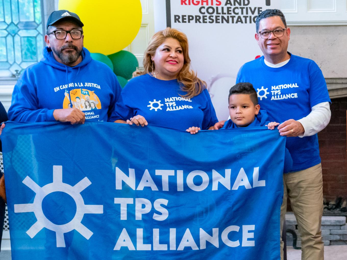 Individuals from the National TPS Alliance standing with a banner. 