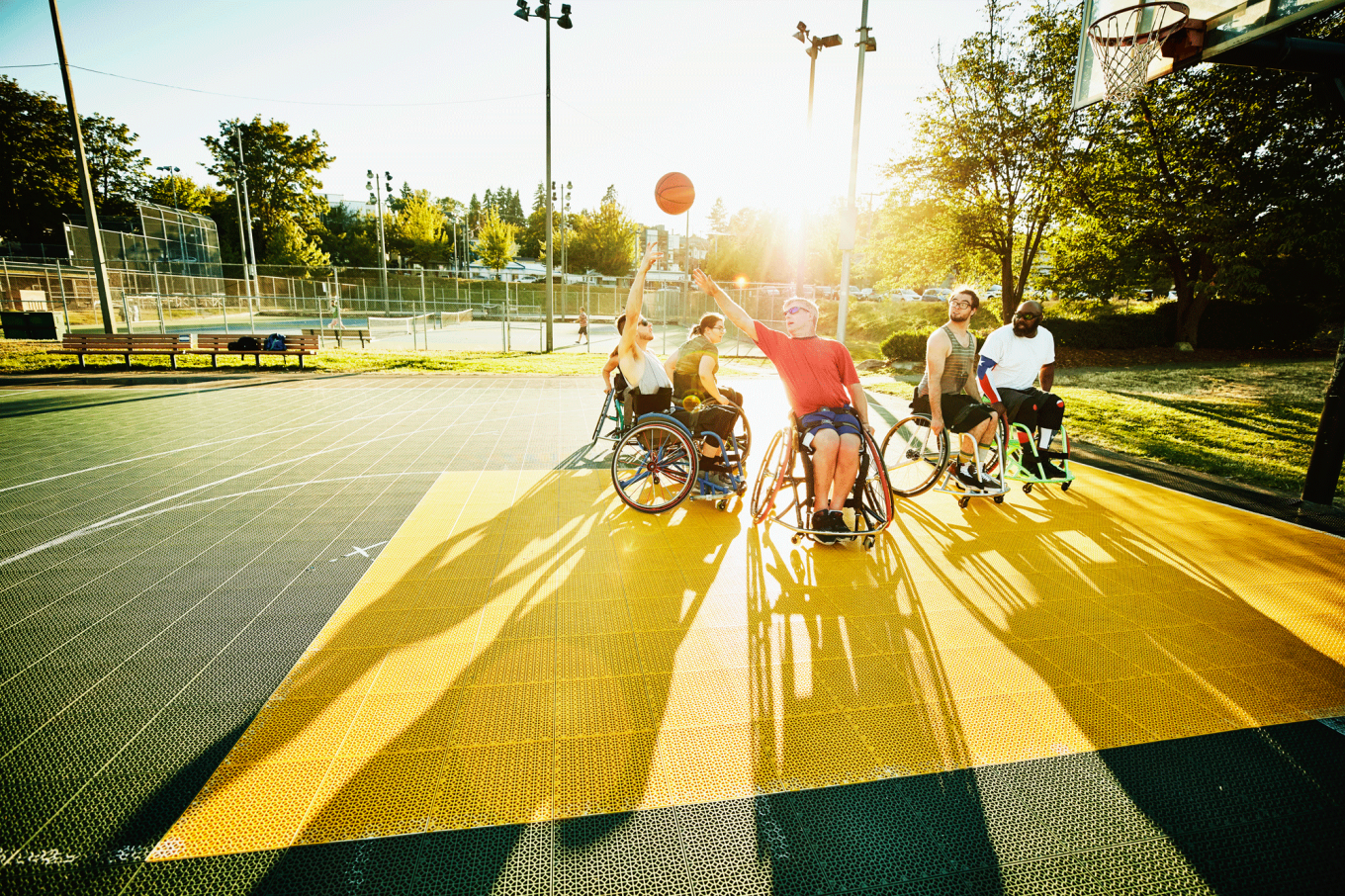 Adaptive athlete taking shot during wheelchair basketball game on outdoor court