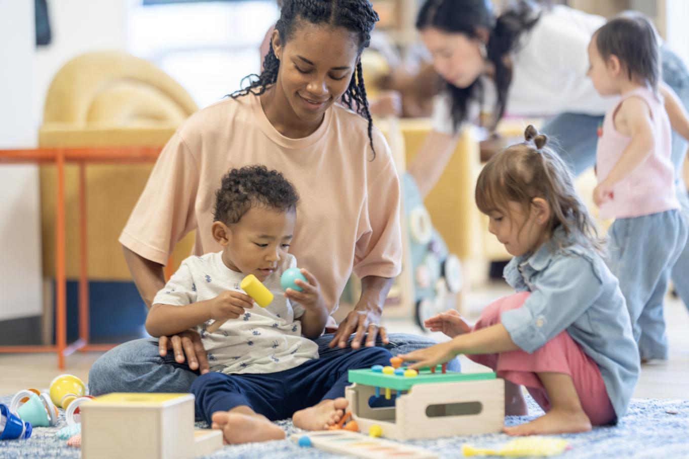 Children and adults enjoying playtime activities in a bright and colorful indoor playroom, fostering creativity.
