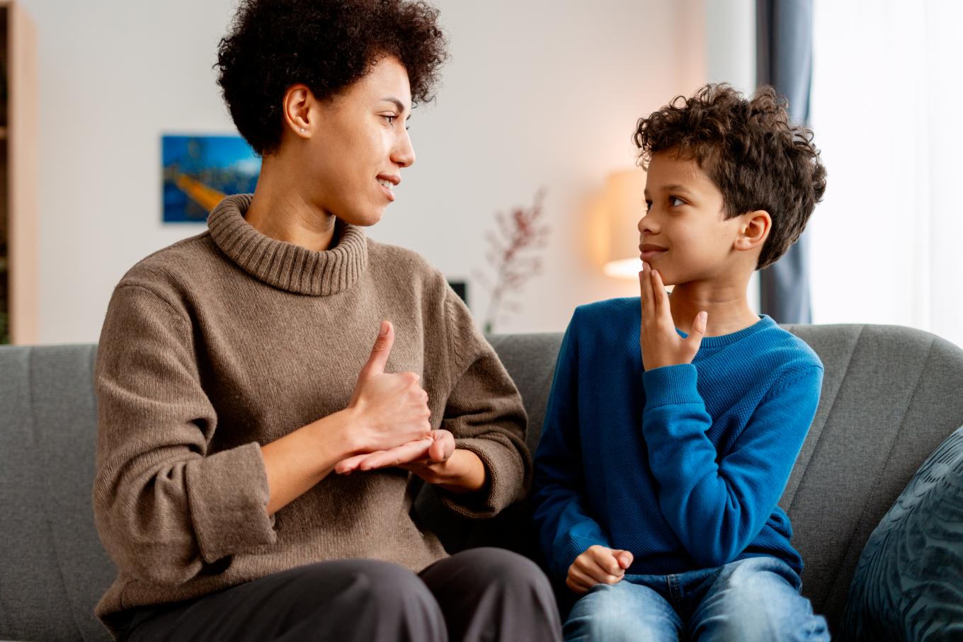 An adult and child use sign language to communicate