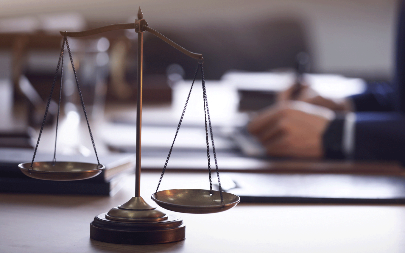  Scales of justice and blurred lawyer on background