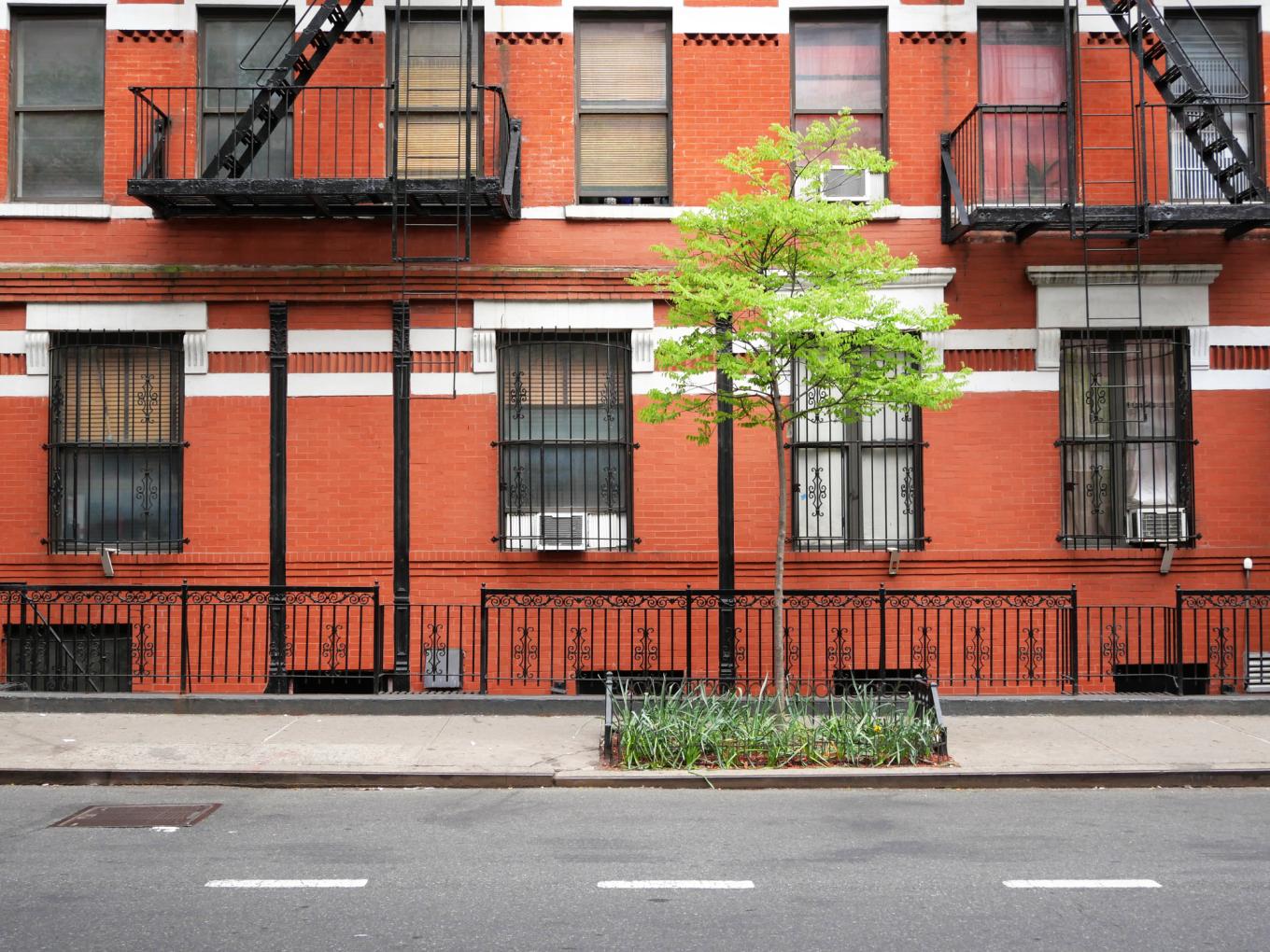  Brick facade of an old building with windows, outdoors staircases and railing in Manhattan