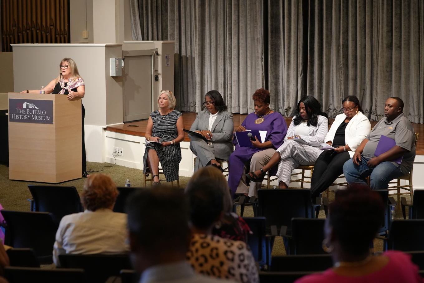 Karen King welcomes attendees to panel discussion
