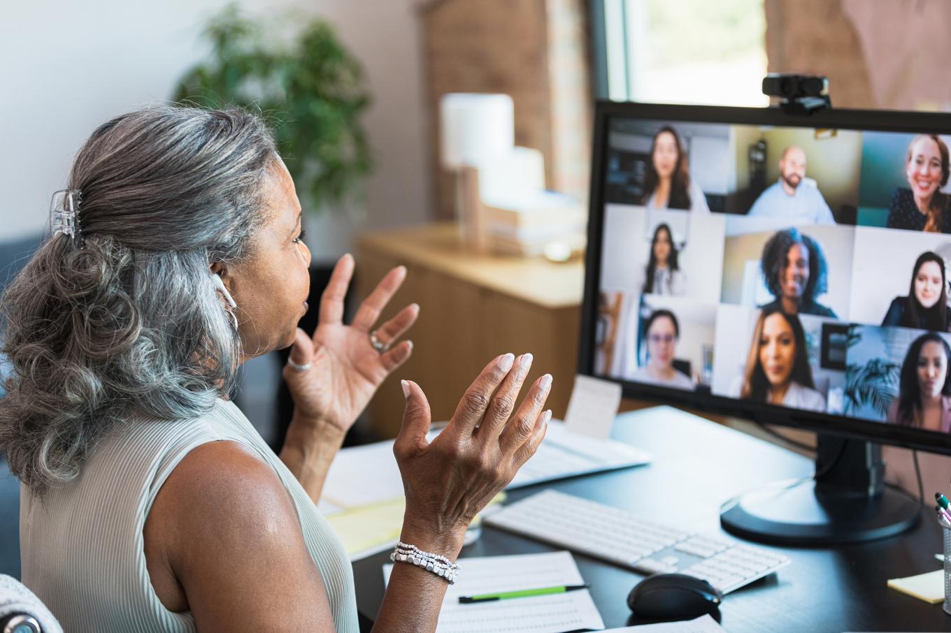 A businessperson participates in a video call with remote colleagues