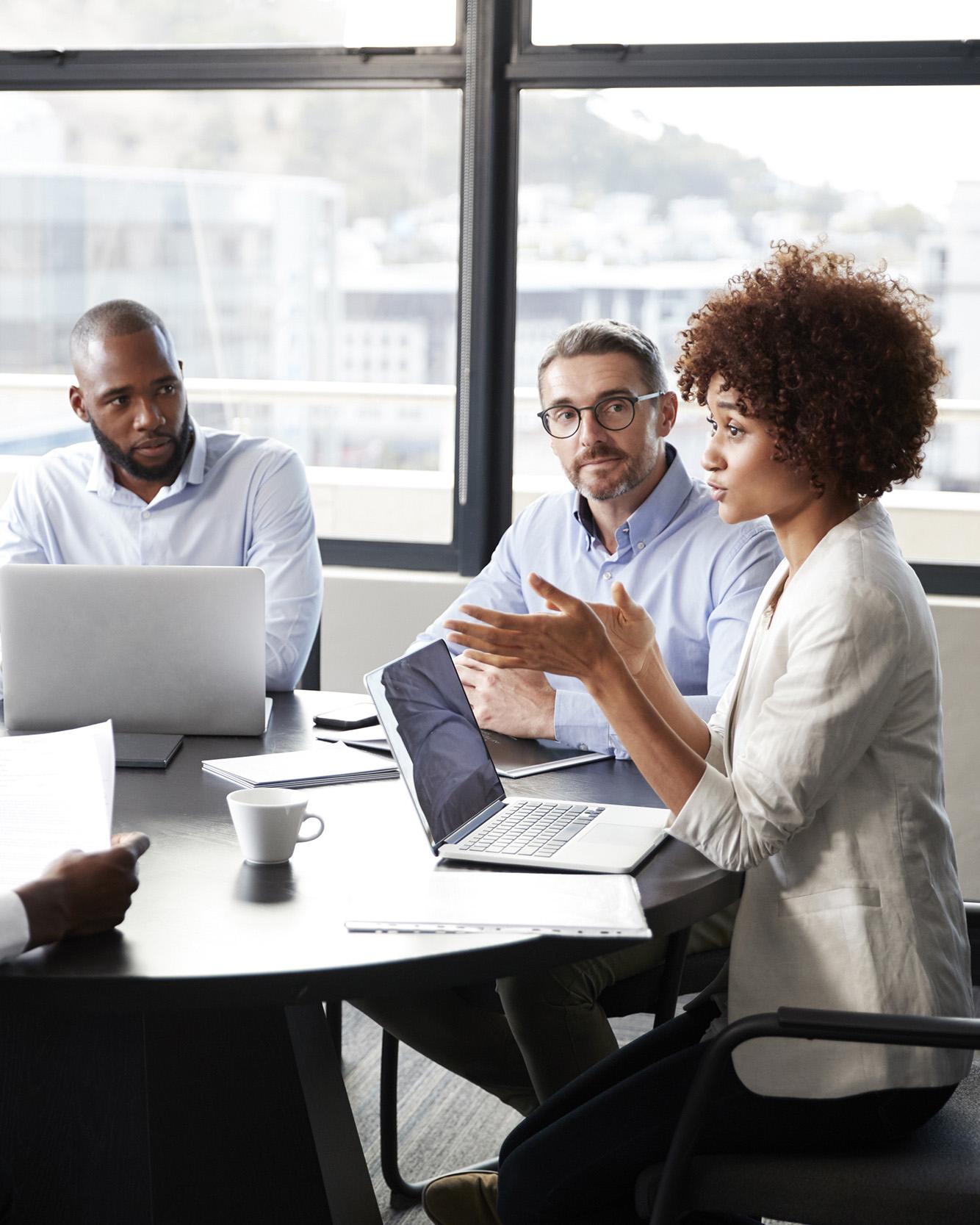 Office workers conversing at a conference table