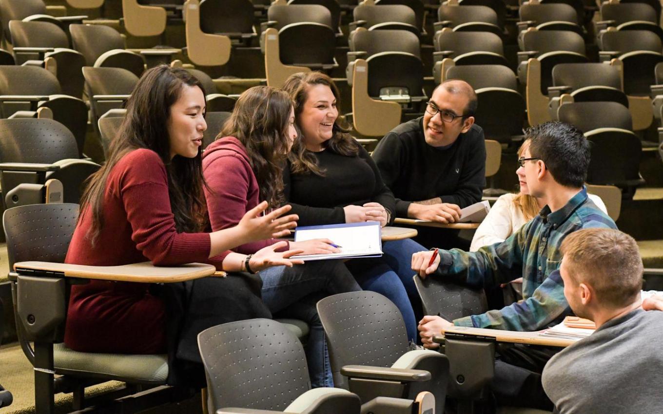 students talking in a circle at desks