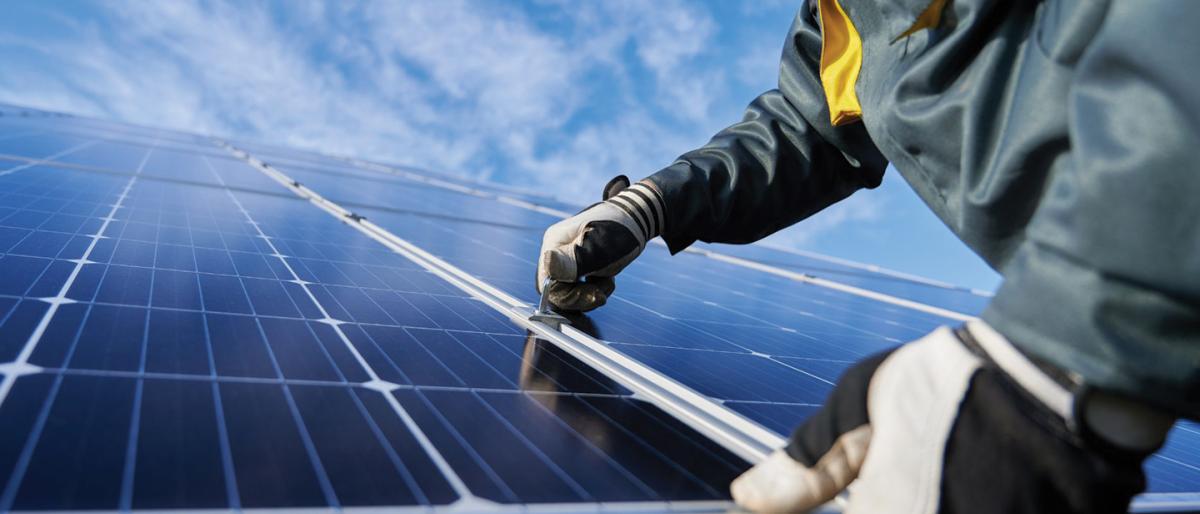 close up view of two hands installing a solar panel