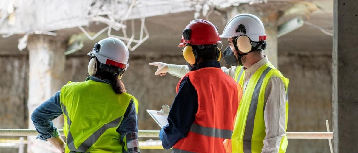Three construction workers, wearing safety gear
