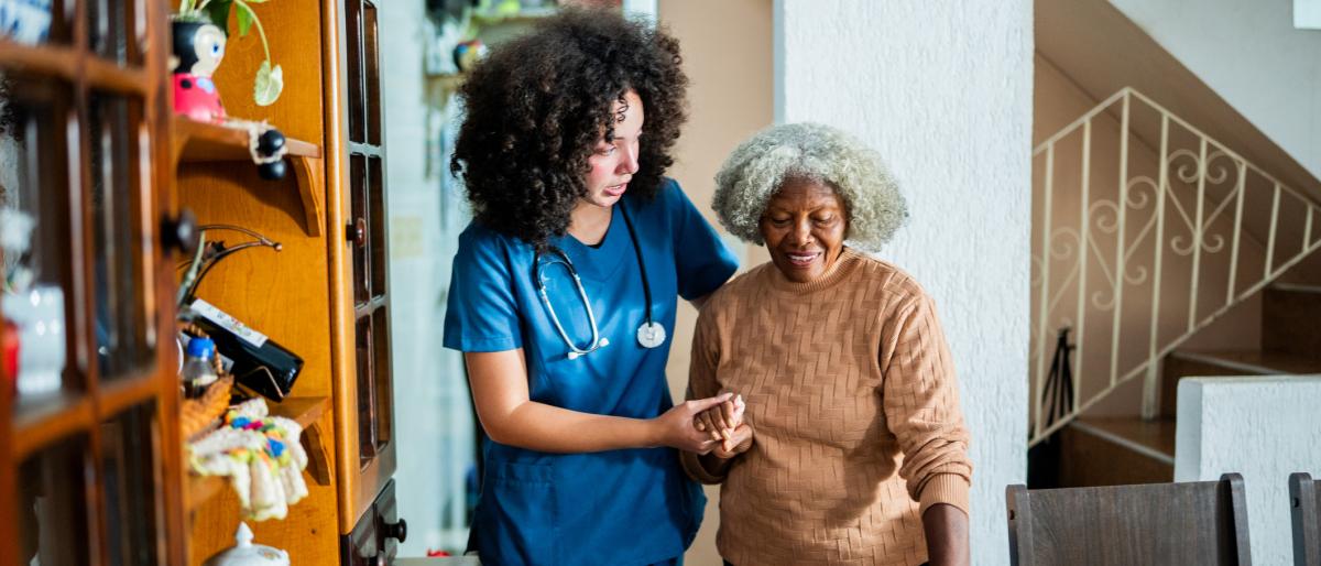 A homecare worker helping elderly woman walk