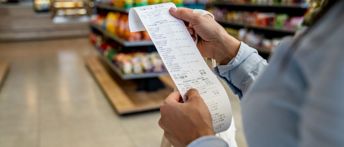 Close-up on a woman shopping at a convenience store and checking her receipt
