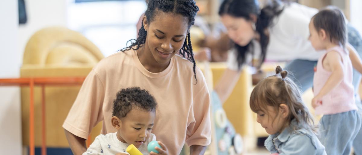 Children and adults enjoying playtime activities in a bright and colorful indoor playroom, fostering creativity.