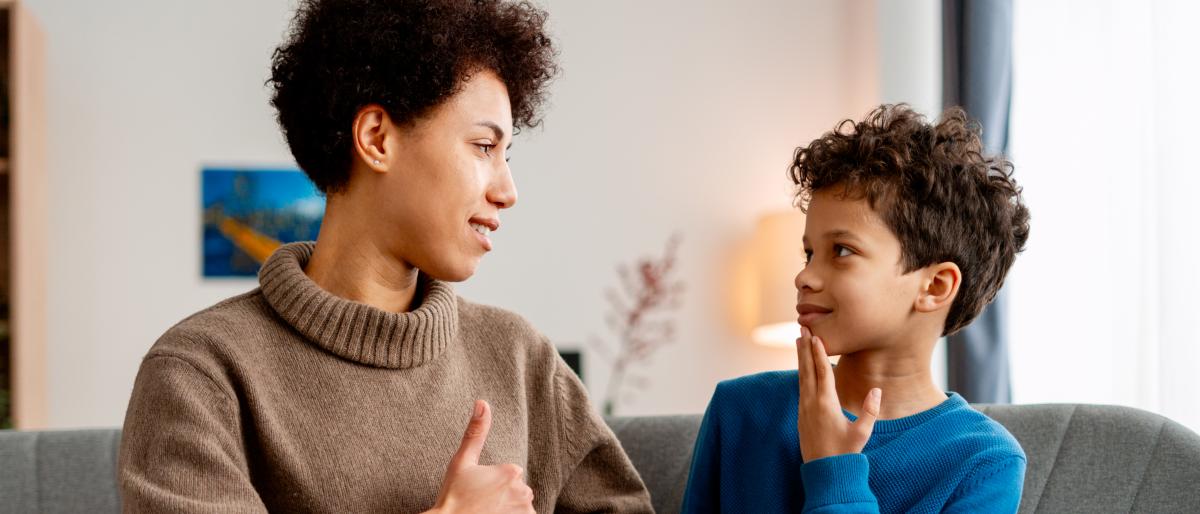 An adult and child use sign language to communicate