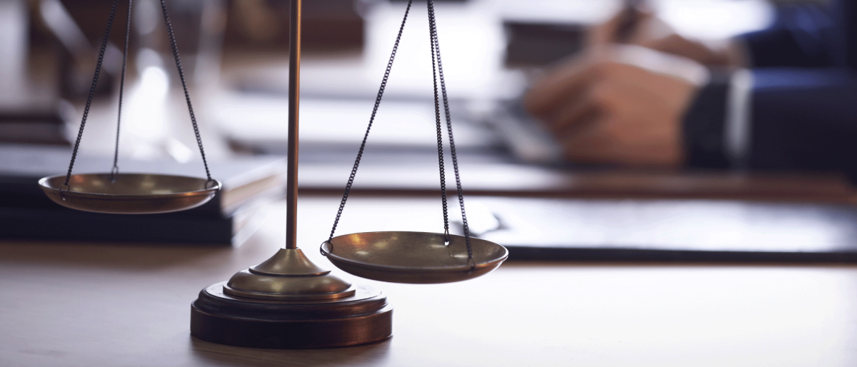  Scales of justice and blurred lawyer on background