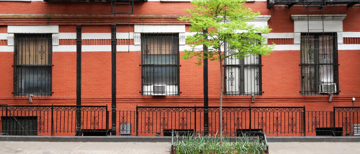  Brick facade of an old building with windows, outdoors staircases and railing in Manhattan