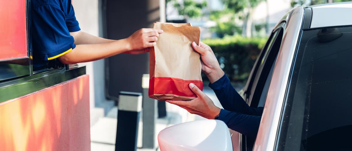 Staff serving takeaway order for driver in delivery window