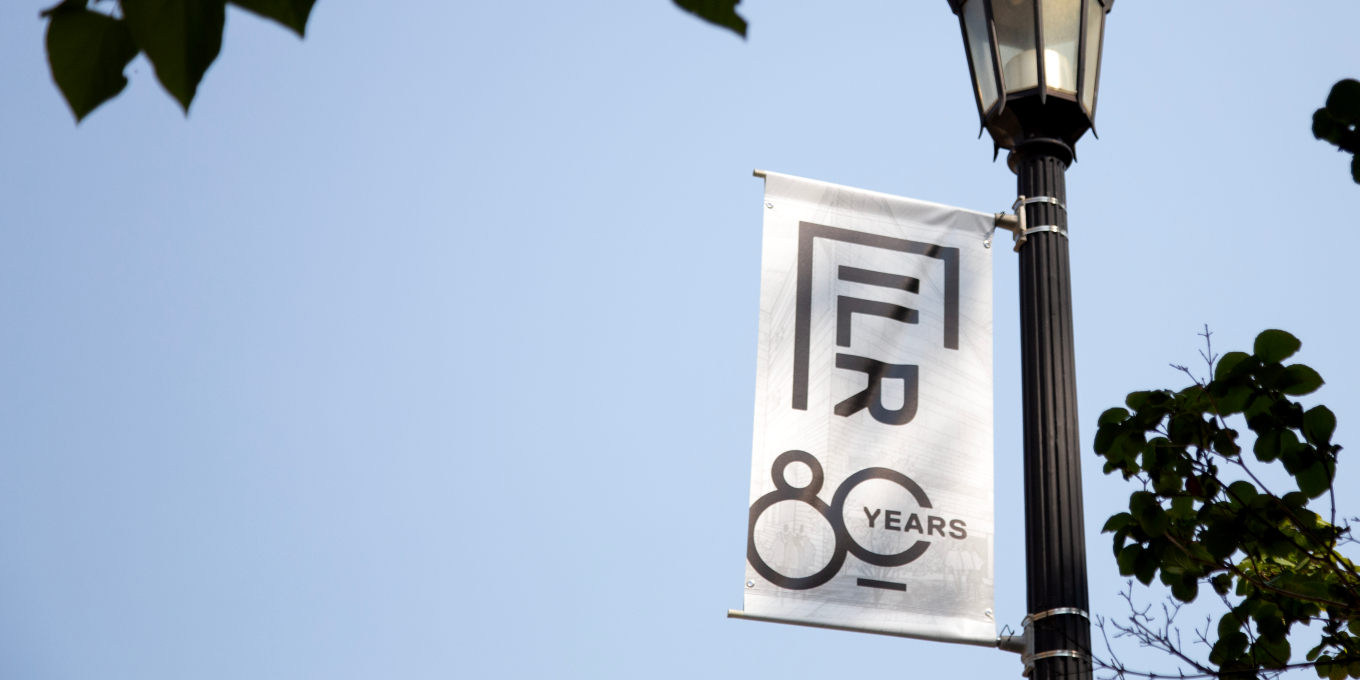 A banner celebrating ILR's 80th anniversary on a light pole. 