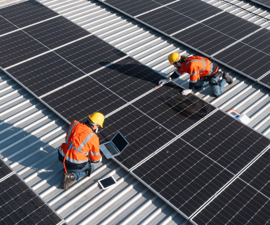two workers on a roof installing solar panels