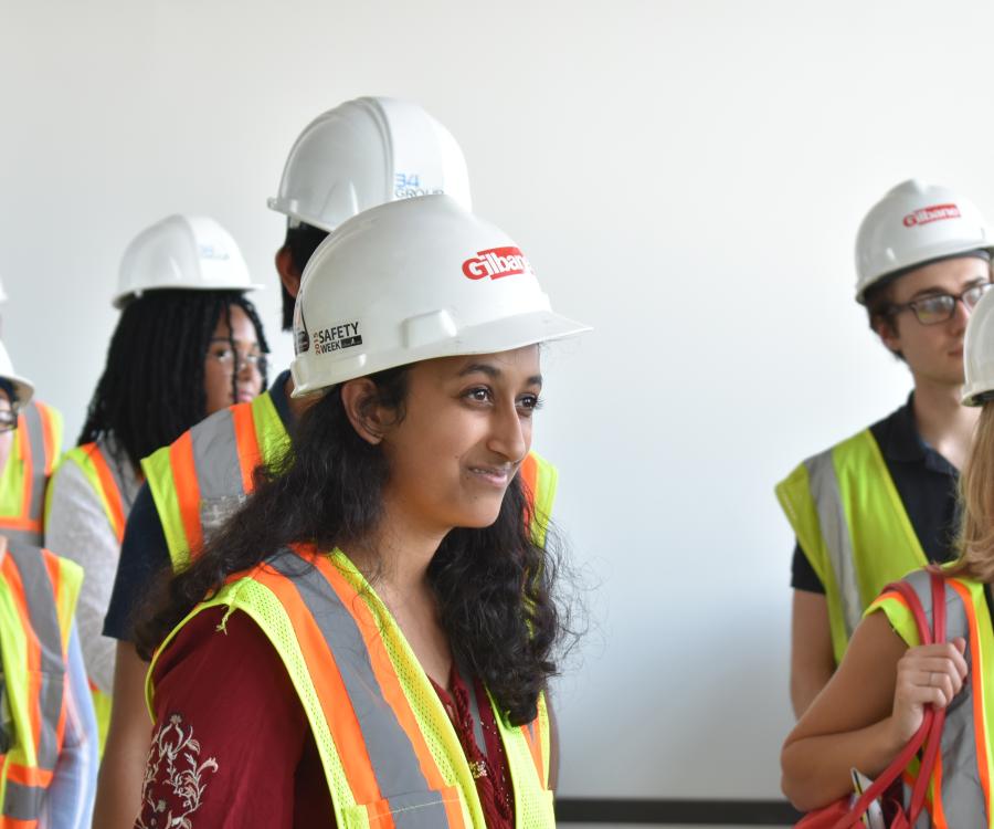 students wear hard hats and high-visability vests