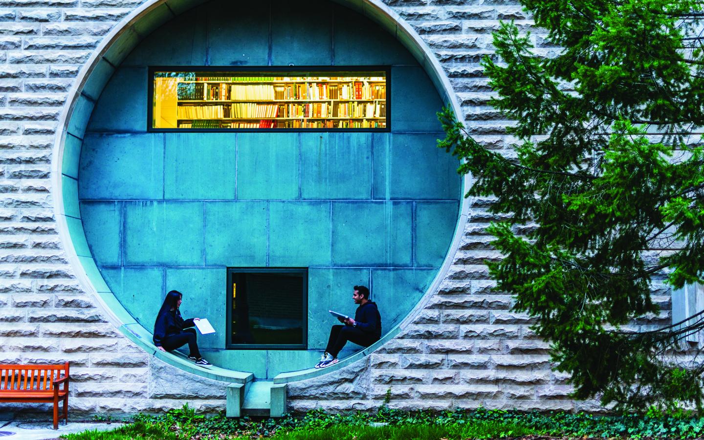 two students sitting in a circular window opening