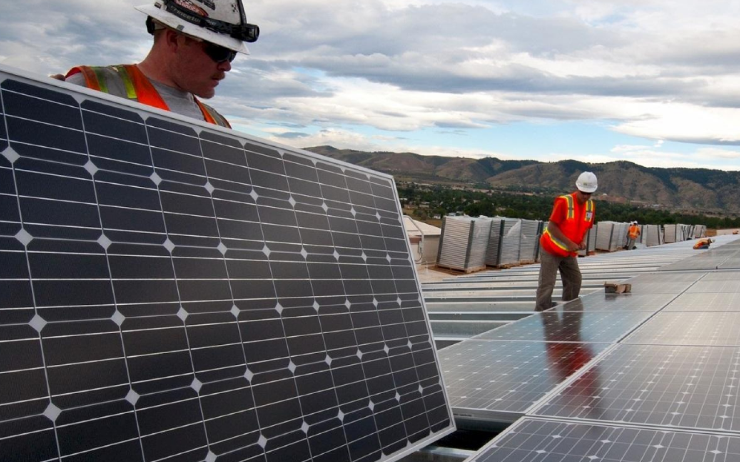 Workers install solar panels
