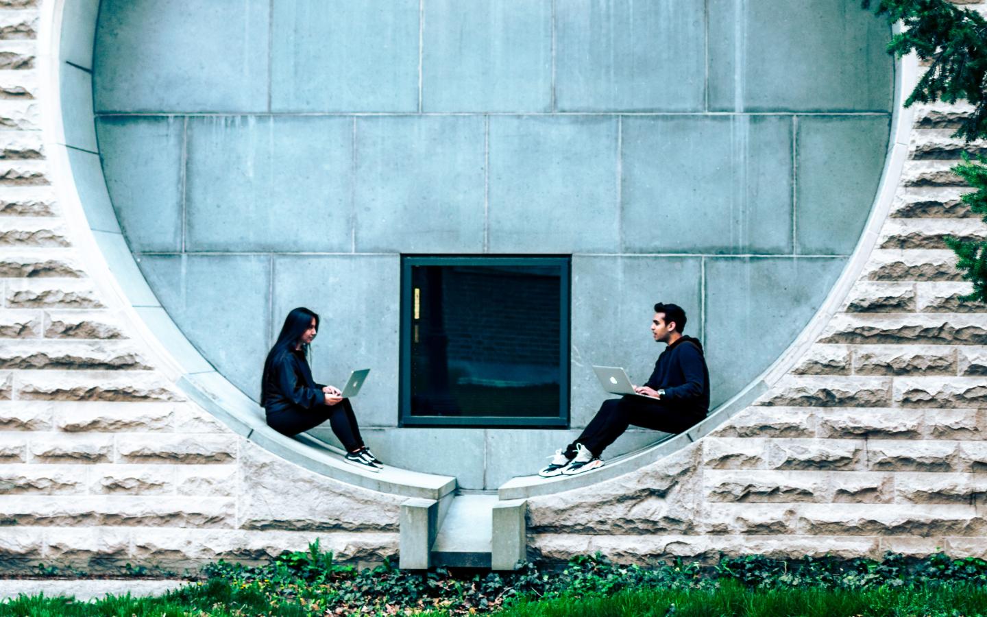 two undergraduate students sit in a circular window