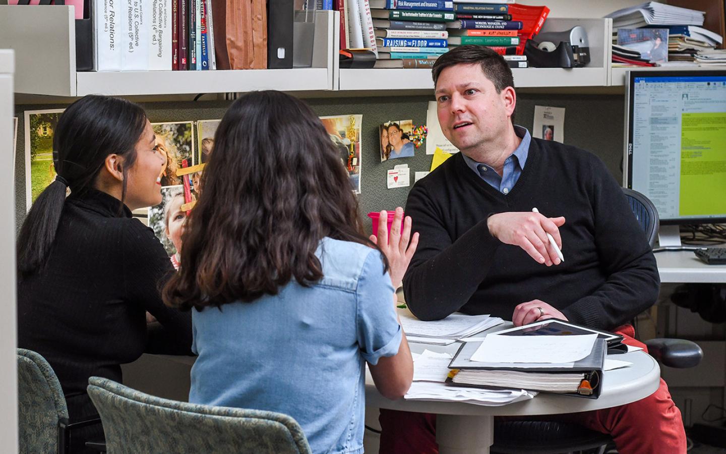 Adam Seth Litwin speaks with two undergraduates in his office in Ives Hall. 