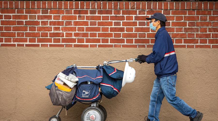 postal worker pushing a cart with mail