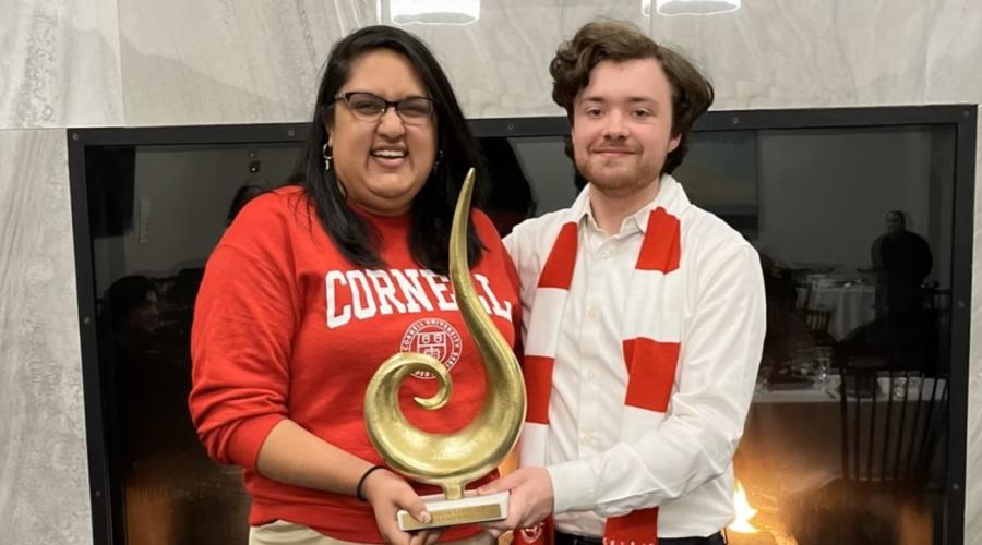 Two students in Cornell apparel hold the winning trophy