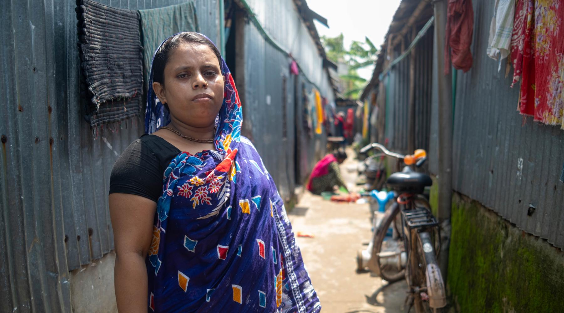 A southasian woman standing looking at camera
