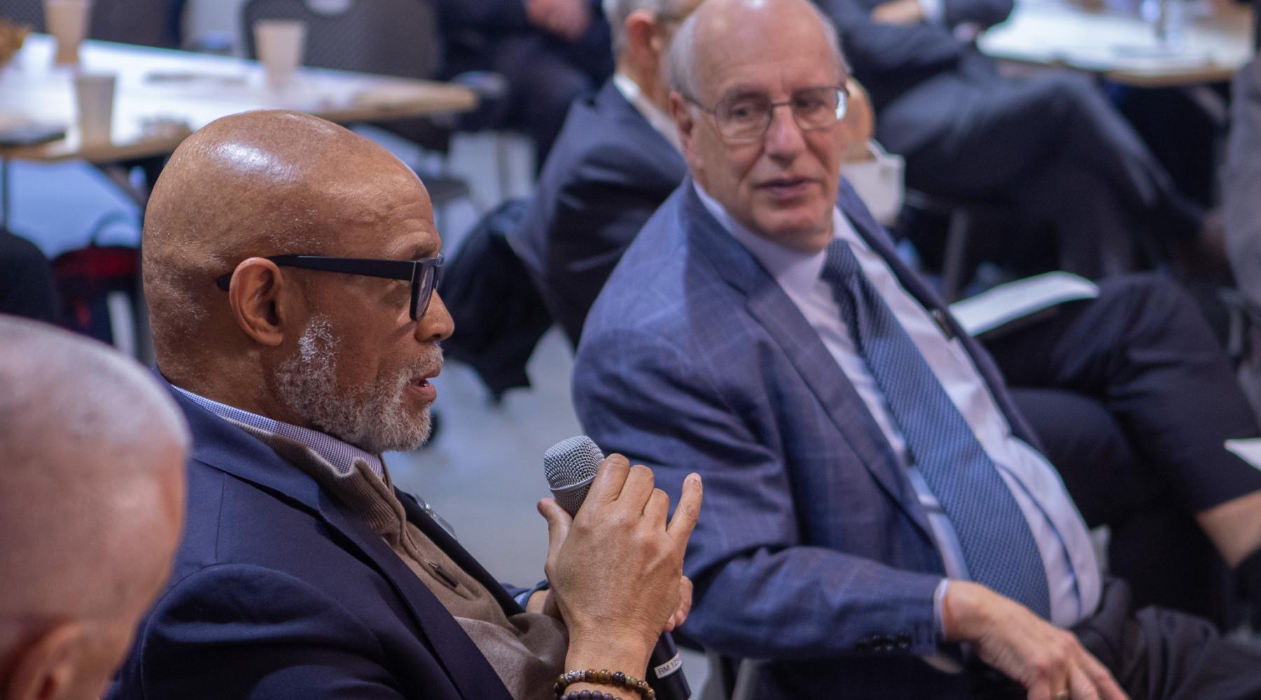 Picture of harry katz speaking to man sitting next to him