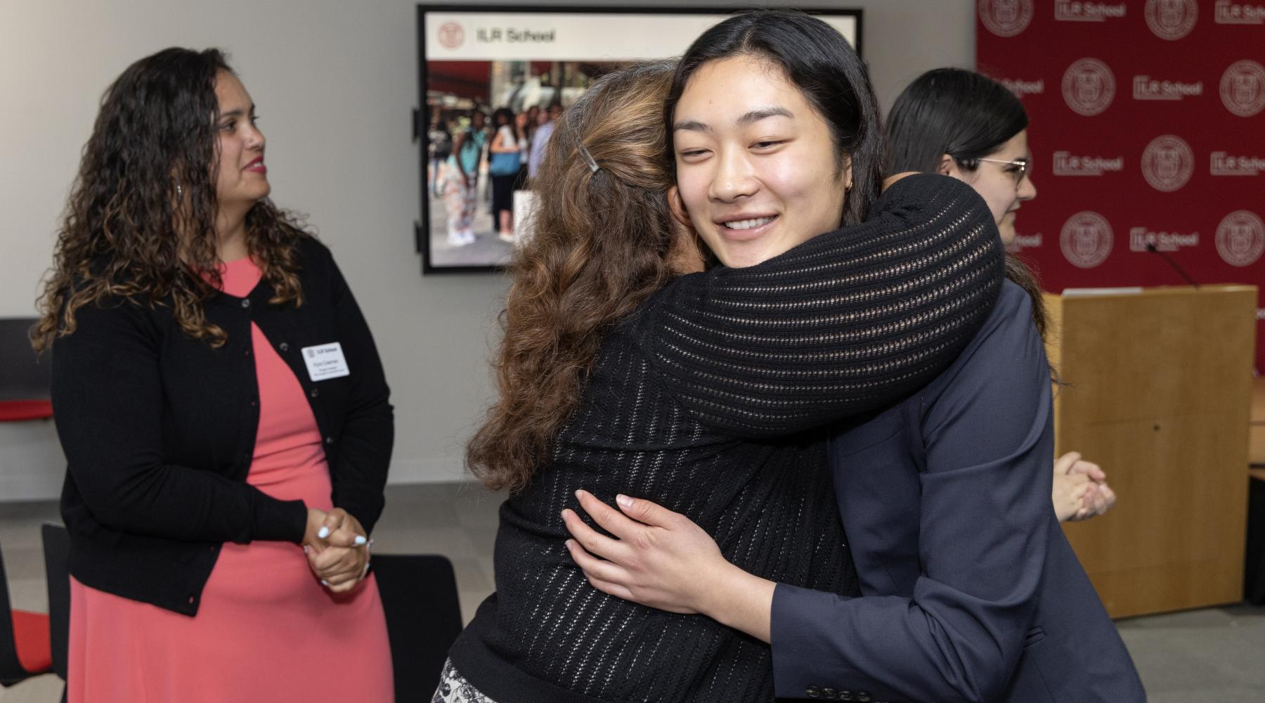 Woman hugging another woman while smiling