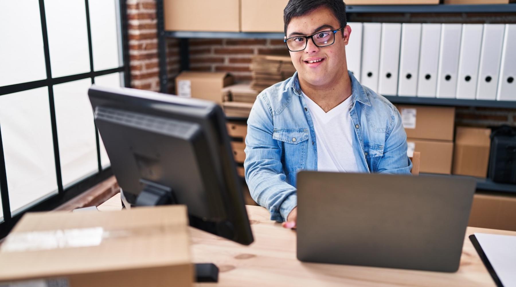 A mailroom employee works with a laptop computer
