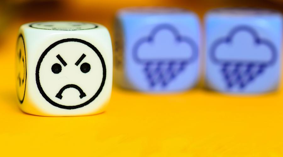 A six-sided die shows an angry emoji with two dice in the background showing rain clouds