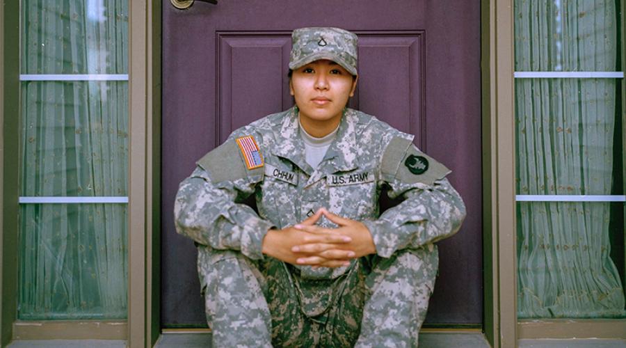 army military member in uniform sitting on doorstep of home