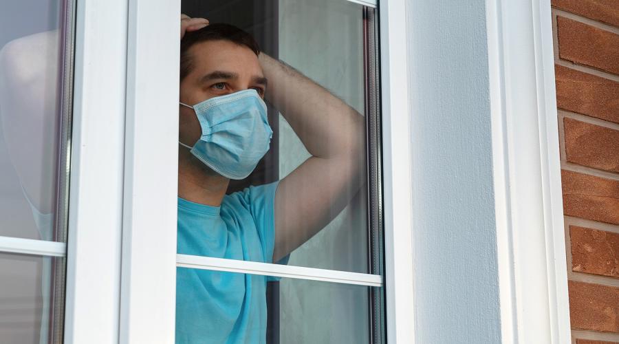Man in a medical mask near the window.