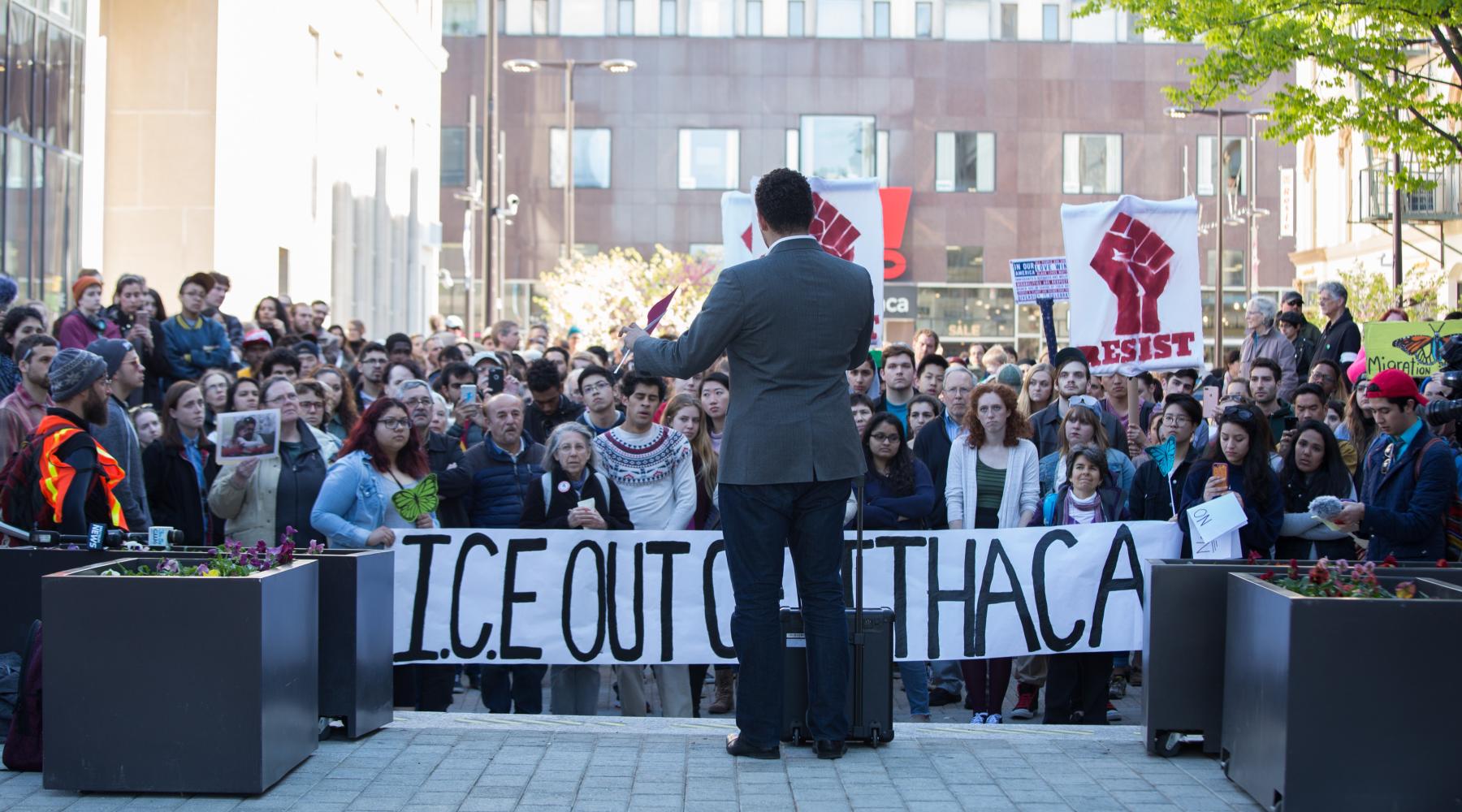 Mayor Svante Myrick speaks at rally for José Guzman-Lopez, who was remanded to U.S. Marshals’ custody on Friday. Hundreds protested his arrest by ICE agents earlier this month in Ithaca. Protestors hold banner reading "ICE OUT OF ITHACA" [Cameron Pollack]