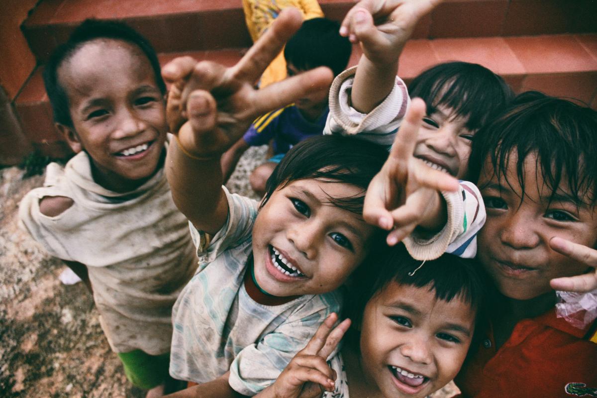 An image of a group of African children smiling and holding their hands