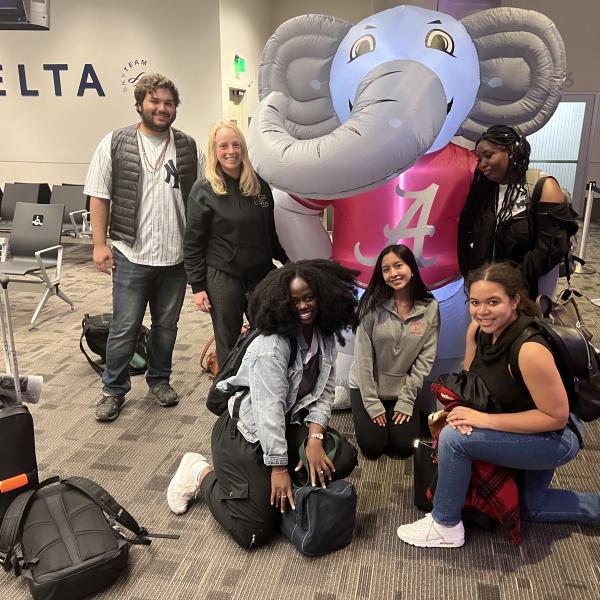 students crowd around an inflatable elephant in the airport